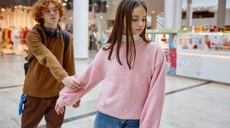Teenage couple having quarrel during date in shopping center. Misunderstanding between young people